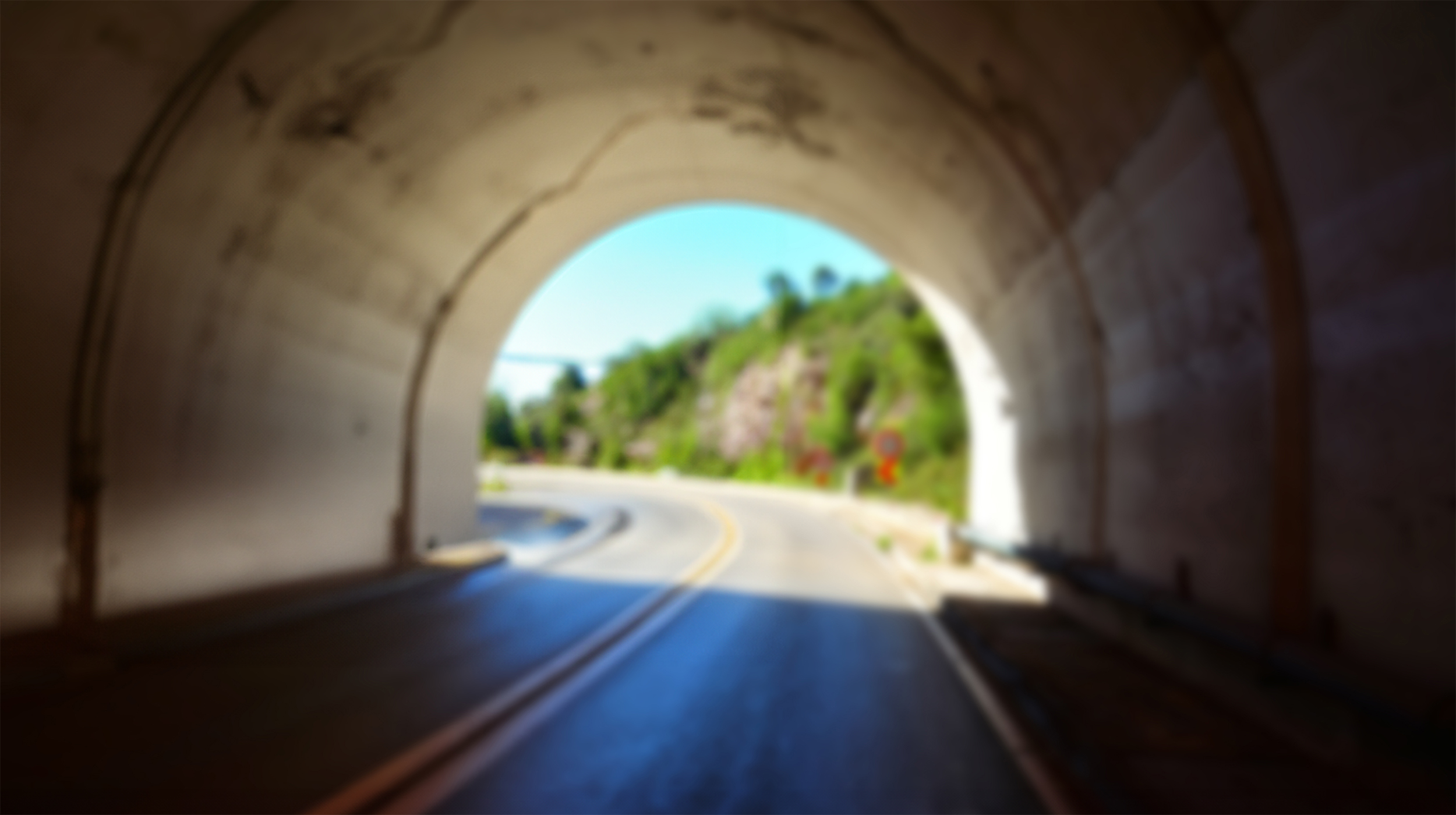 The interior of a tunnel—light shining at the end—is seen in the background.