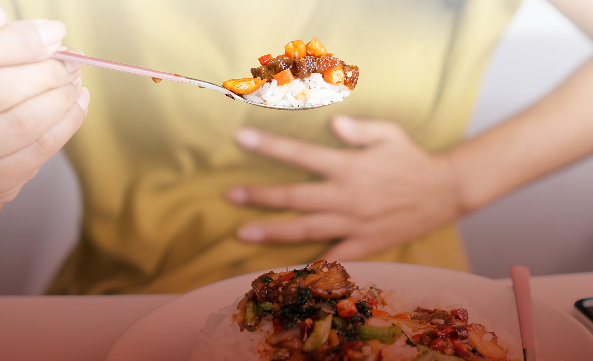 Woman eating spicy food while holding her stomach.